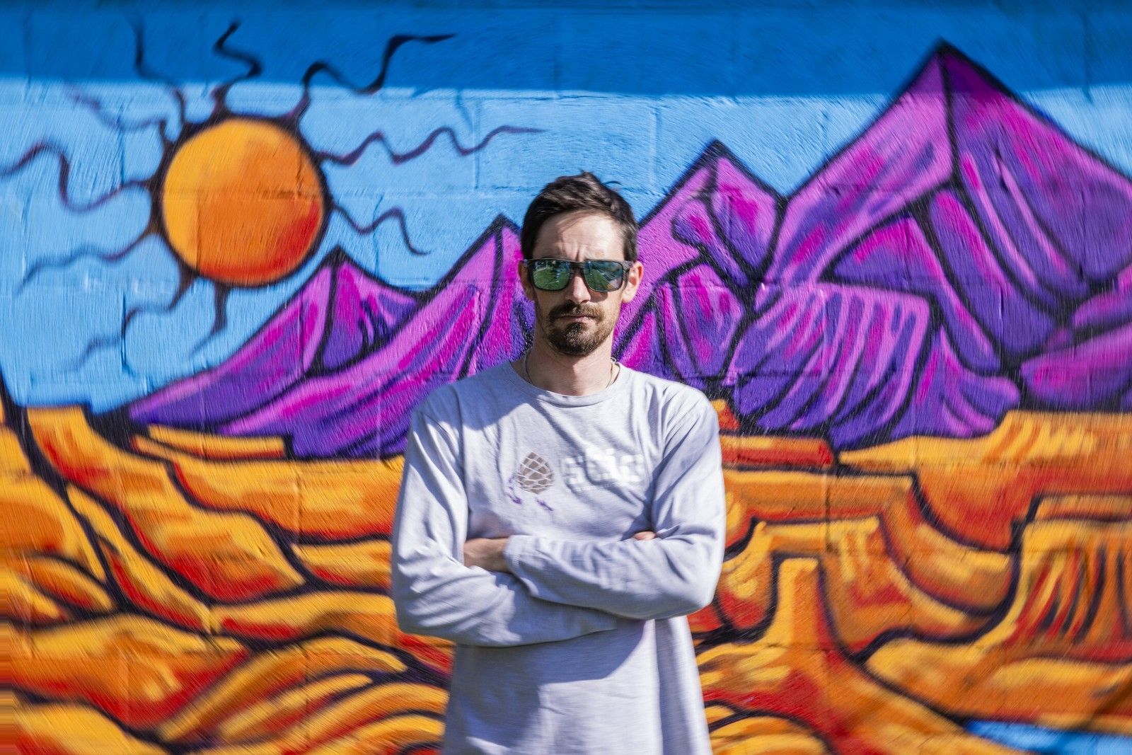Andrew in front of a desert arch mural