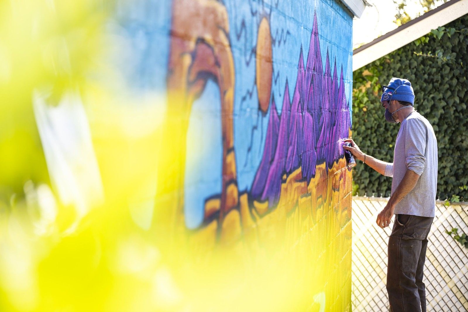 Painting a mural, framed by flowers