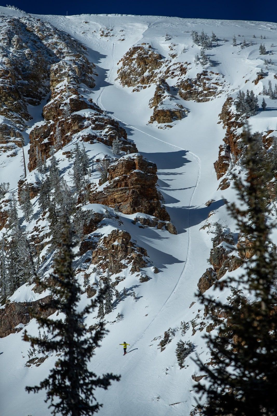 Lone skier below a cliff band on Mount Baldy